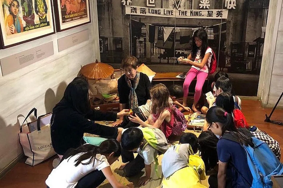 KEGIATAN MENARIK: Kanak-kanak berpeluang untuk menyertai sesi bercerita mengenai sejarah dan warisan Singapura (gambar atas) dan menyertai peraduan mewarna dan sekali gus membantu kanak-kanak yang kurang bernasib baik. - Foto MUZIUM NEGARA