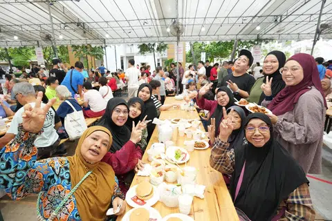 Cik Fazidah Aziz (duduk di bahagian kanan, berbaju merah) bersama anggota keluarga dan rakan-rakannya di acara Hari Ibu pada 12 Mei di Fernvale.