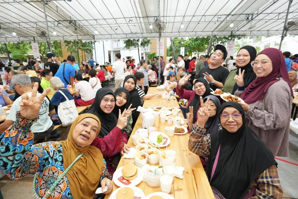 Cik Fazidah Aziz (duduk di bahagian kanan, berbaju merah) bersama anggota keluarga dan rakan-rakannya di acara Hari Ibu pada 12 Mei di Fernvale.