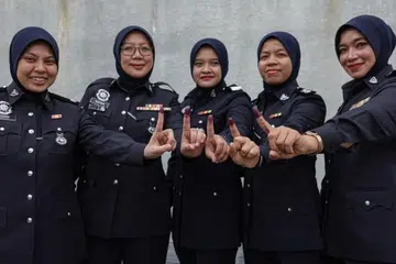 Anggota polis menunjukkan jari yang telah dicelup dakwat selepas selesai mengundi di Ibu Pejabat Polis Daerah Nilai sempena hari pengundian awal bagi Pilihan Raya Negeri (PRN) Negeri Sembilan ke-16, pada 28 Julai.