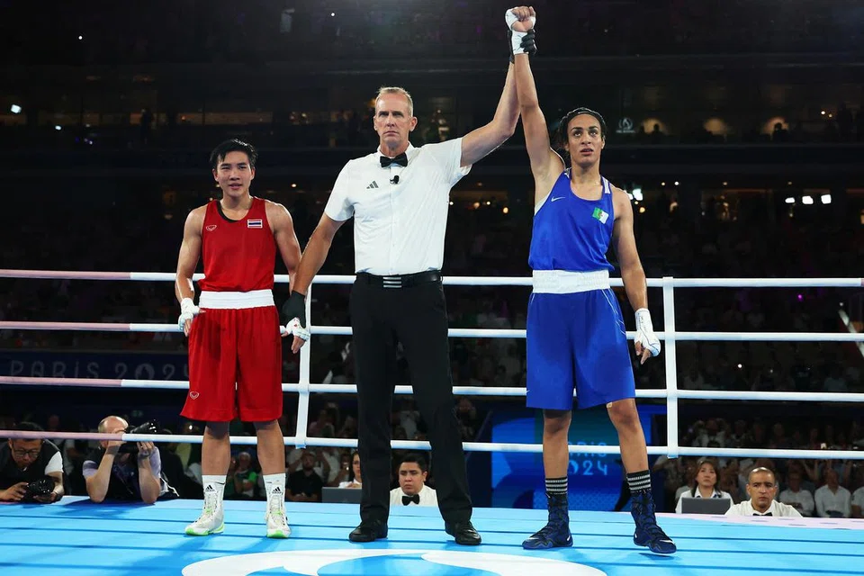 Pengadil perlawanan, Shawn Reese (tengah), mengangkat tangan petinju Imane Khelif (kanan), untuk mengisytiharkan beliau sebagai pemenang dalam pertarungan menentang Janjaem Suwannapheng dari Thailand. 