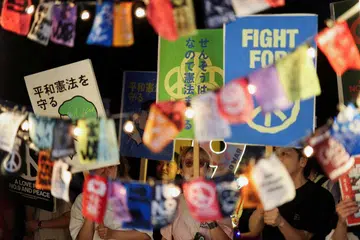 Penunjuk perasaan memegang sepanduk dan lampu ketika berhimpun di hadapan bangunan Parlimen di Tokyo pada 29 Mei 2026 bagi membantah pentadbiran Perdana Menteri Jepun, Sanae Takaichi, termasuk cadangan pindaan perlembagaan dan peluasan ketenteraan. Perhimpunan itu berlangsung ketika kerajaan Jepun memperketat peraturan media sosial bagi pilihan raya, termasuk mewajibkan kandungan imej dan video janaan kecerdasan buatan dilabel untuk mengekang maklumat palsu serta melindungi keadilan proses demokrasi.
