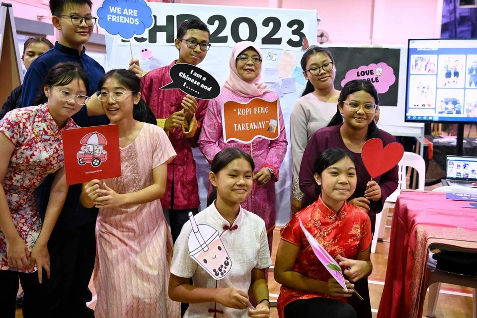 SAMBUT BERSAMA: Mantan Presiden Puan Halimah Yacob (belakang, tengah) bergambar bersama pelajar semasa sambutan Hari Keharmonian Kaum di Sekolah Menengah Northbrooks pada 20 Julai 2023.
