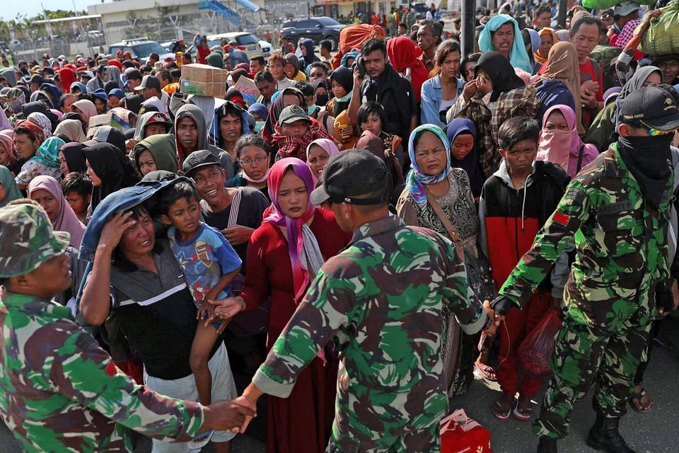 BERPINDAH: Penduduk yang terjejas akibat gempa dan tsunami yang melanda Palu, Sulawesi Tengah menunggu untuk dipindahkan pesawat tentera di Lapangan Terbang Mutiara Sis Al Jufri. - Foto REUTERS