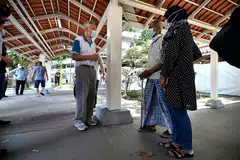 SAPA PENDUDUK: PM Lee berbual dengan penduduk yang telah menjalani ujian swab di laluan berbumbung dekat Blok 460A Ang Mo Kio Avenue 10 semalam. Kelmarin, beliau menggalak warga emas yang belum mendapatkan vaksin Covid-19 supaya mendapatkannya dengan segera agar tidak terlewat. - Foto BH oleh LIM YAOHUI