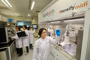 Ketua Saintis, Dr Zhang Huibin (depan), bersama para juruteknik, (belakang, dari kiri ke kanan) Cik Chen Huishan, Cik Ng Sze Wai dan Cik Sim Lyn Chiin membuat demonstrasi bagi proses peningkatan dan pembentukan mRNA.
