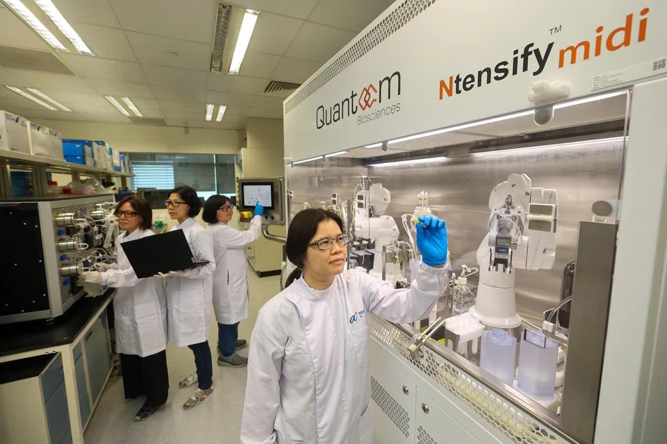 Ketua Saintis, Dr Zhang Huibin (depan), bersama para juruteknik, (belakang, dari kiri ke kanan) Cik Chen Huishan, Cik Ng Sze Wai dan Cik Sim Lyn Chiin membuat demonstrasi bagi proses peningkatan dan pembentukan mRNA.