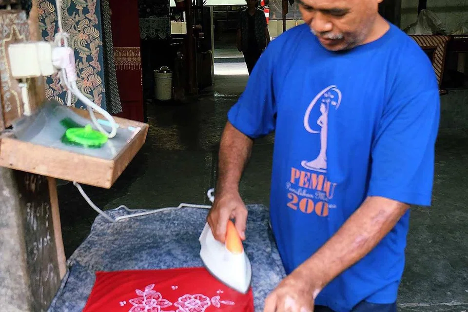 Para pengunjung boleh belajar membuat batik semasa mengunjungi galeri batik seperti sapu tangan yang sedang digosok pekerja ini. 