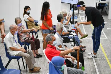 WARGA TUA TUNGGU GILIRAN UNTUK DIVAKSIN: Menurut Kementerian Kesihatan, bilangan orang yang mengalami sakit teruk atau meninggal dunia akibat dijangkiti Covid-19 adalah 1.1 peratus dalam kalangan mereka yang telah divaksin sepenuhnya. Gambar menunjukkan pusat vaksinasi di Kelab Masyarakat Toa Payoh West. - Foto fail