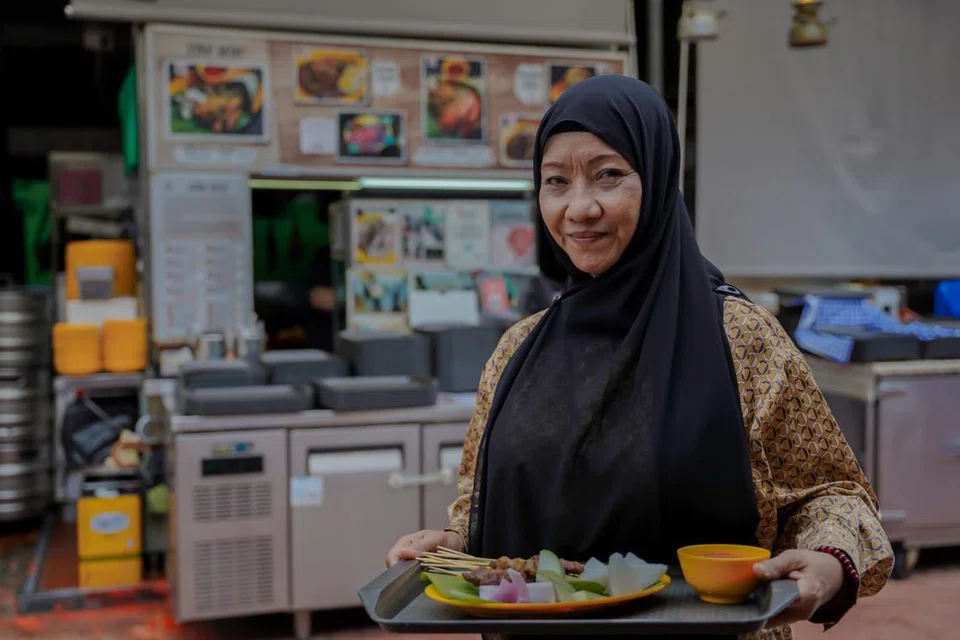 KINI USAHAWAN BERJAYA: Faridah Dollah kini gigih mengendalikan perniagaan Syifa’ Satay di Makansutra Gluttons Bay dan menyediakan pelbagai juadah kepada pelanggan. 