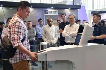 KHIDMAT LEBIH CANGGIH: Menteri Ehwal Dalam Negeri merangkap Undang-Undang, Encik K. Shanmugam (tengah) menyaksikan replika lorong Sistem Kawalan Sempadan Automatik di Pusat Kebudayaan Universiti (UCC), Universiti Nasional Singapura (NUS) semalam. - Foto BH oleh NG SOR LUAN