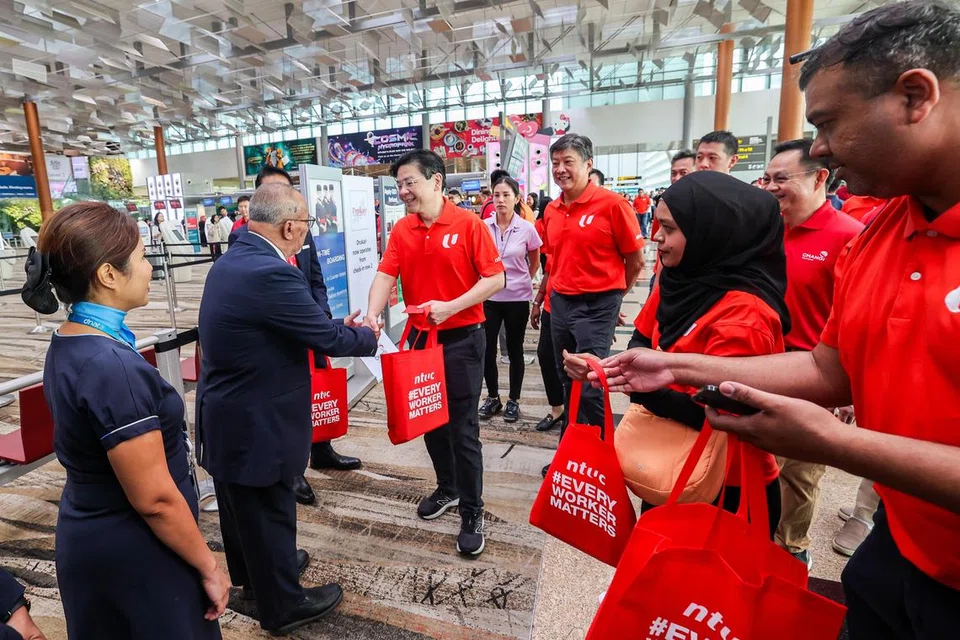 Perdana Menteri, Encik Lawrence Wong (tengah), memberi beg mengandungi oren, hongbao daripada NTUC dan hadiah kantung kepada pekerja di Lapangan Terbang Changi pada 28 Januari 2025. Turut dalam gambar ialah Setiausaha Agung NTUC, Encik Ng Chee Meng (di belakang PM Wong).