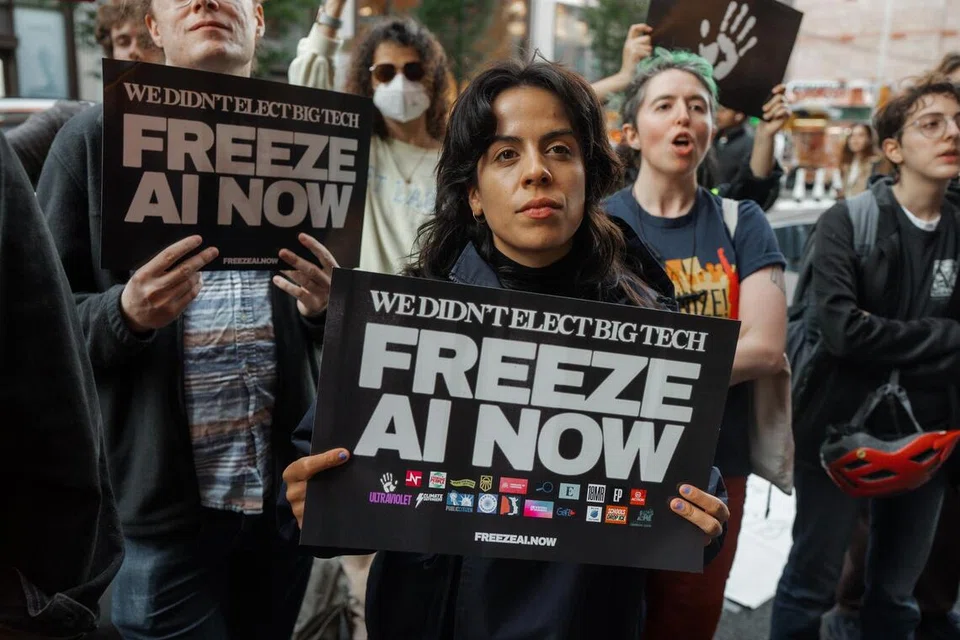 Penunjuk perasaan memegang sepanduk bertulis ‘We Didn’t Elect Big Tech, Freeze AI Now’ (“Kami tidak memilih syarikat teknologi gergasi, hentikan pembangunan AI sekarang.”) ketika menyertai perhimpunan membantah kecerdasan buatan (AI) di luar bangunan yang menempatkan pejabat OpenAI di SoHo, New York, pada 20 Oktober 2026. New York kini memperkenalkan undang-undang baru yang melarang chatbot AI bertindak sebagai teman peribadi kepada pengguna bawah 18 tahun, selain mewajibkan pengesahan usia bagi melindungi kanak-kanak dan remaja daripada risiko pergantungan emosi terhadap teknologi tersebut.