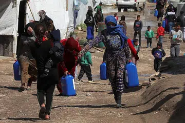 MAKIN RAMAI PERLU BANTUAN: Pelarian Syria berjalan sambil membawa kontena di sebuah kem tidak rasmi di lembah Bekaa, Lebanon. Kira-kira 24 juta rakyat Syria memerlukan bantuan kemanusiaan asas, bertambah seramai empat juta orang sepanjang setahun lalu. - Foto REUTERS