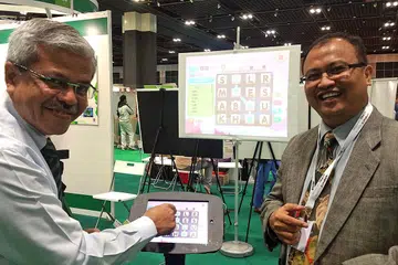 LUASKAN KOSA KATA: Encik Mohamed Noh Daipi (kiri) dan Encik Rahmat Subadah sedang menunjukkan bagaimana aplikasi Pintar Kata dapat meluaskan kosa kata pelajar yang menggunakannya. - Foto SHAHIDA SARHID