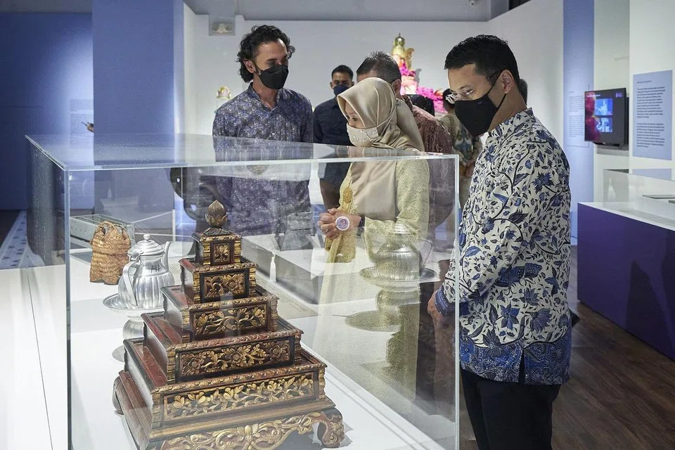 HARGAI BUDAYA MELAYU: Encik Desmond Lee (paling kanan) dan Cik Rahayu Mahzam sedang melihat antara artefak yang terdapat di Taman Warisan Melayu semasa pelancaran Pesta Budaya Melayu minggu lalu. - Foto TAMAN WARISAN MELAYU