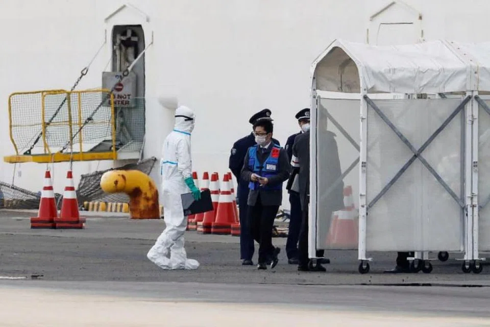 Pekerja menggunakan pakaian pelindung berdekatan kapal pelayaran Diamond Princess di Terminal Pelayaran Daikoku Pier di Yokohama, Jepun. FOTO: REUTERS