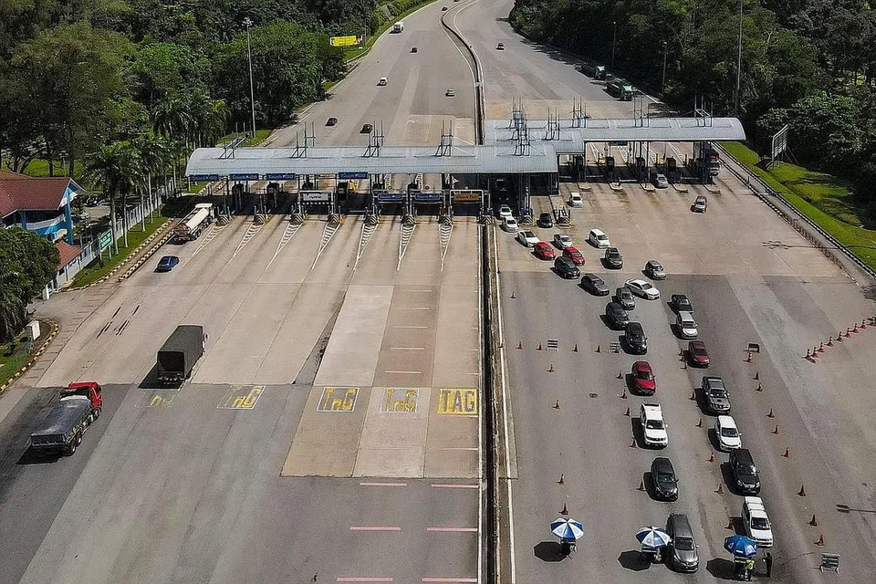PERIKSA KENDERAAN: Satu pandangan udara menunjukkan polis mengendalikan sekatan jalan raya di Lebuhraya Pantai Timur (Kuala Lumpur - Karak) dan memeriksa pergerakan kenderaan di kawasan itu sedang rakyat Malaysia mula menyambut Hari Raya Aidilfitri hari ini. - Foto AFP