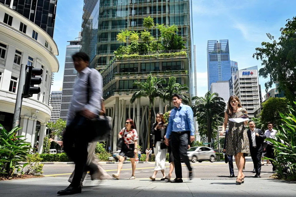 Sekumpulan pekerja pejabat melintas jalan raya dekat Cecil Street semasa waktu rehat makan tengah hari.