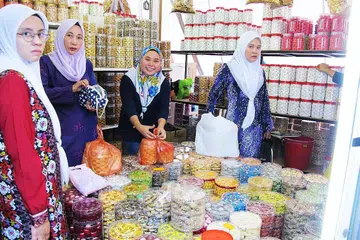 PERMINTAAN TINGGI KUIH-MUIH: Cik Aida Fitriyah (dua dari kanan) yang sedang melayan pelanggan, mendapati warga Singapura lebih suka kuih klasik.