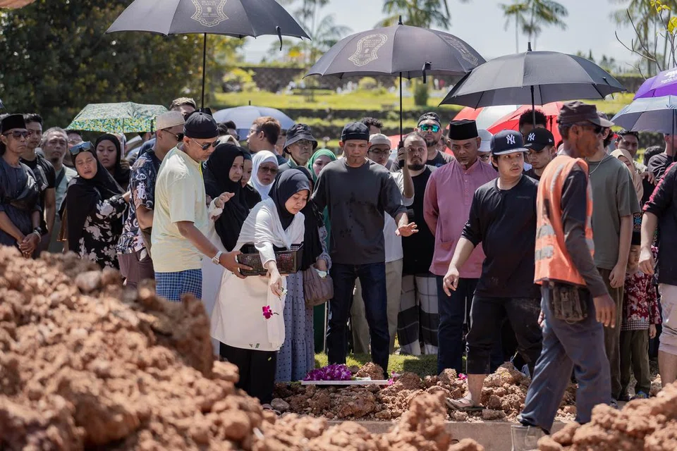 Tunang Allahyarham Mohammad Shahfiq, Cik Lili Afini Zahit, 27 tahun, kelihatan menaburkan bunga di kubur Allahayarham.