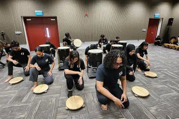 BERGENDANG SAMBIL BERCERITA: Ahli Kumpulan Nadi Singapura sedang giat berlatih untuk persembahan minggu depan di Victoria Theatre.