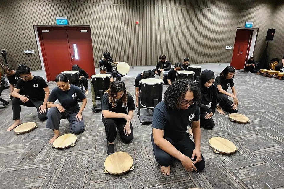 BERGENDANG SAMBIL BERCERITA: Ahli Kumpulan Nadi Singapura sedang giat berlatih untuk persembahan minggu depan di Victoria Theatre.