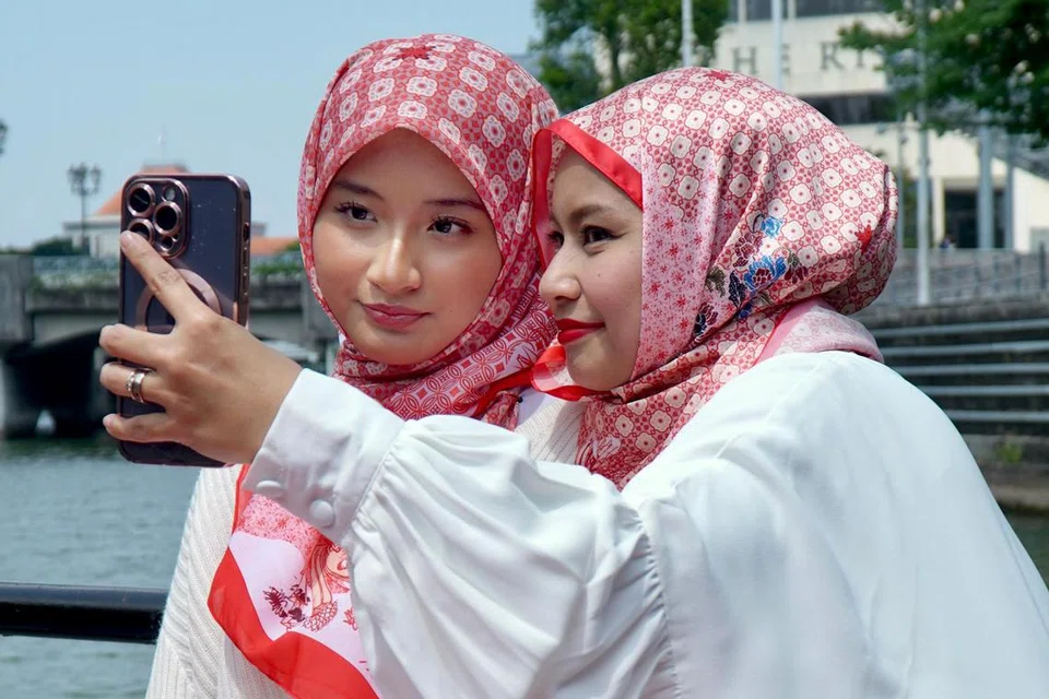 Datin Diyana Halik (kanan) gembira kerana anak bongsunya, Dahlia Arissa, 14 tahun, mahu menemaninya menggayakan tudung edisi khas, SG59, yang mempunyai desain lambang kebangsaan Singapura.