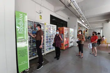 BANTUAN MAKANAN MELALUI MESIN: Keluarga penerima bantuan The Food Bank Singapore kini boleh mendapatkan bantuan makanan mereka dari mesin layan diri Food Pantry 2.0 di empat estet perumahan, dengan rancangan melancarkan 20 mesin baru menjelang akhir tahun ini. - Foto BANK MAKANAN SINGAPURA