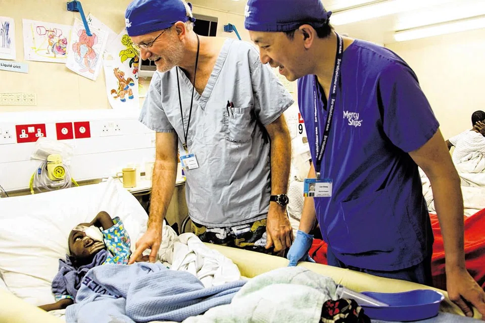 MENYUMBANG KHIDMAT: Ketua Pegawai Perubatan Africa Mercy, Dr Gary Parker (kiri), bersama pakar bedah sukarelawan Encik Leo Cheng daripada United Kingdom melawat pesakit yang telah mendapat pembedahan di atas kapal hospital awam terbesar di dunia. - Foto MERCY SHIPS / DEBRA BELL