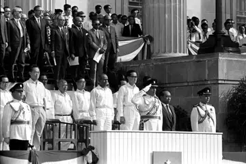 Presiden pertama Singapura, Encik Yusof Ishak (baris depan, tiga dari kanan), dalam pakaian seragam, menabik hormat apabila lagu kebangsaan dimainkan semasa Perbarisan Hari Kebangsaan (NDP) 1966. Beliau diringi anggota kabinet yang dipimpin oleh Perdana Menteri Pengasas Singapura, Encik Lee Kuan Yew (baris depan, dua dari kiri).