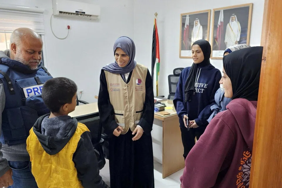BERPELUANG TINJAU GAZA: Menteri Negara Qatar untuk Kerjasama Antarabangsa di Kementerian Luar Negara, Cik Lolwah  Rashid Al Khater (tengah) bercakap dengan seorang budak lelaki Palestin di lokasi yang tidak diketahui, ketika beliau melawat Gaza semasa gencatan senjata sementara antara Hamas dengan Israel pada 26 November.