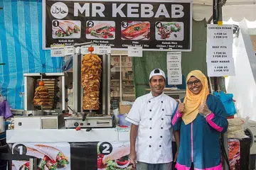 RESIPI TERSENDIRI: Encik Rahim (kiri) menggunakan 48 kilogram daging ayam di gerainya di bazar Geylang Serai setiap hari. - Foto ZALEHA ABDUL KADER
