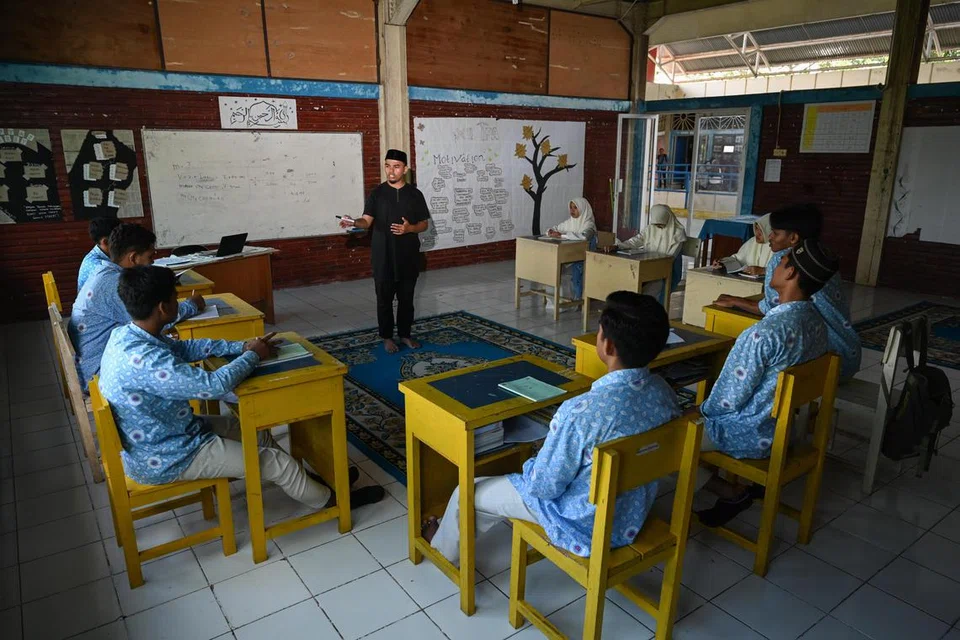 Ustaz Wildanum Mukhalladun, 23 tahun, seorang guru Al-Quran, gigih membimbing murid di Sekolah Berasrama Fajar Hidayah, Aceh Besar, pada 6 Disember 2024. Fajar Hidayah ditubuhkan selepas tsunami 2004 untuk menyediakan pendidikan kepada kanak-kanak di Aceh yang terjejas oleh bencana tersebut. Sekolah itu kini menjadi tempat pembelajaran bagi pelajar pelbagai latar belakang, menggabungkan pendidikan akademik dengan agama dalam usaha membangunkan generasi masa depan.