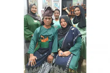SEMANGAT KEKELUARGAAN: Encik Diham Ahmad bersama isterinya, Cik Sulasthri Yasin (duduk di sebelahnya) dan tiga orang anak mereka berpakaian tradisional buat sambutan Hari Raya. - Foto FACEBOOK ENCIK DIHAM AHMAD