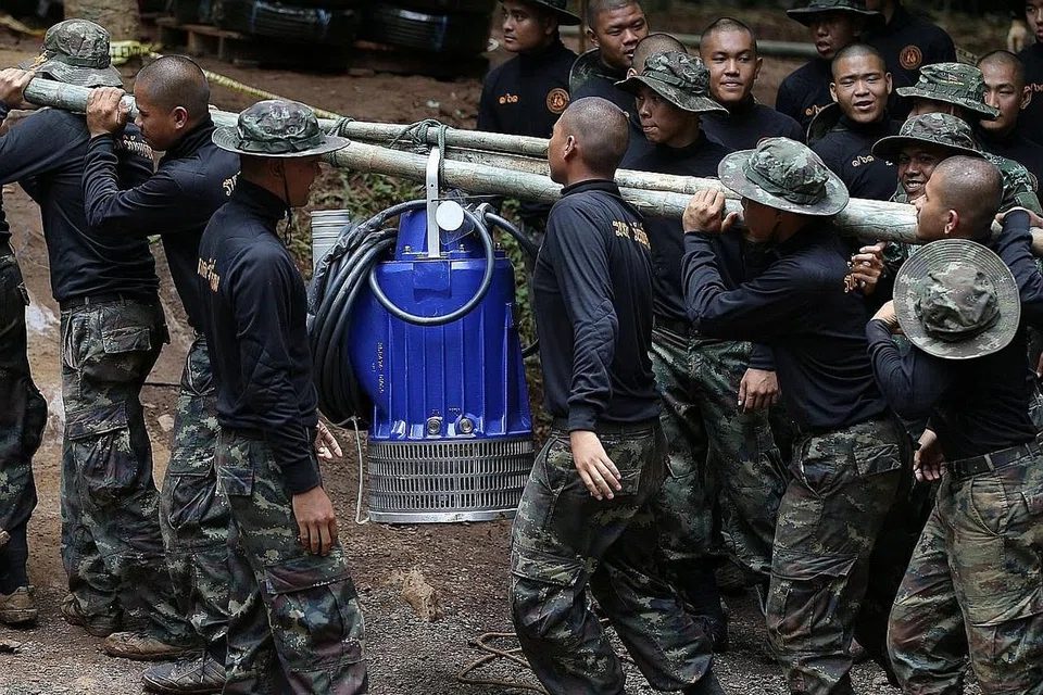 BERTUNGKUS LUMUS: Pegawai tentera Thailand semalam mengusung mesin pam air ke mulut Gua Tham Luang, Chiang Rai, demi menyelamatkan mangsa terperangkap. - Foto REUTERS