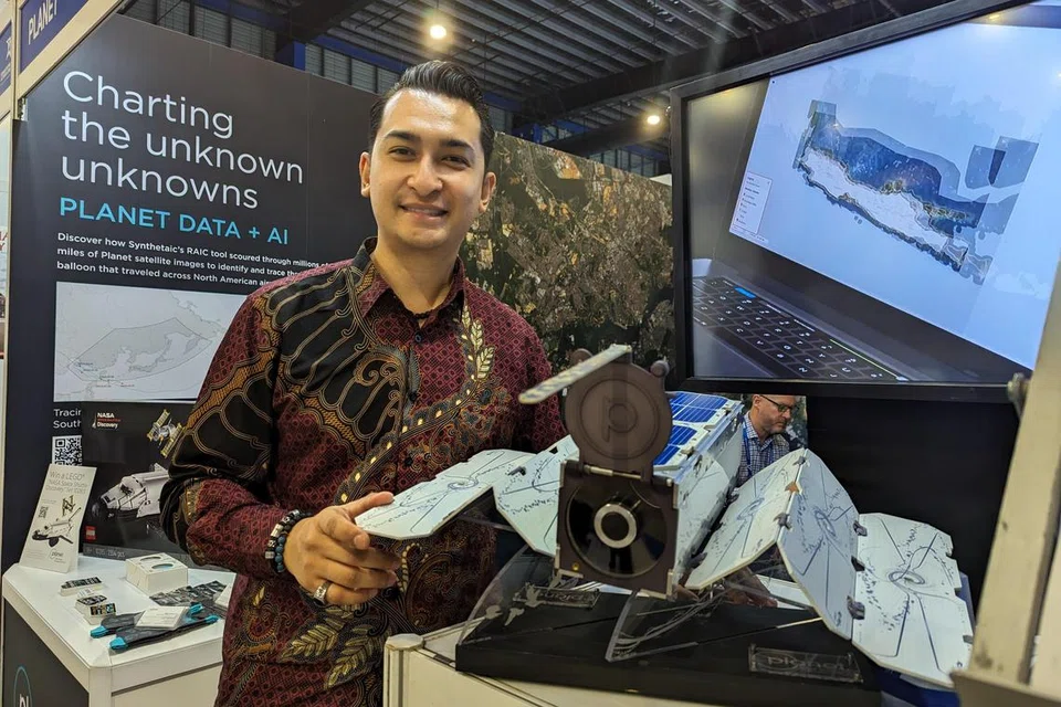 Setelah 10 tahun bertugas sebagai pramugara, Encik Agil Basalamah, kini menceburi bidang imejan dan analitik satelit. Beliau berdiri di sebelah model satelit yang dilancarkan syarikatnya.