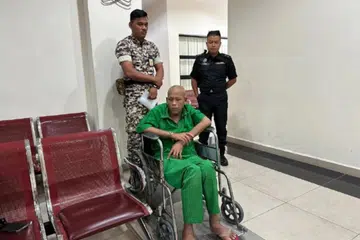 Azman Mohamed Nor berkerusi roda akibat penyakit saraf didakwa di Mahkamah Tinggi Muar pada 9 Julai atas tiga tuduhan membunuh.