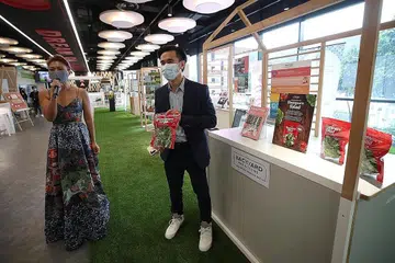 HAB KULINARI BARU: Cik Ng bersama pengarah urusan X-Inc, Encik Nicholas Ng, menunjukkan antara produk syarikat makanan yang meraih manfaat daripada hab kulinari XPACE, yang dilancarkan Encik Gan semalam. - Foto BH oleh TIMOTHY DAVID