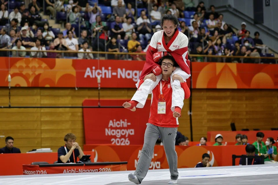 Jaguh seni bela diri campuran (MMA) Singapura, Tiffany Teo, diangkat oleh jurulatih yang juga suaminya, Sim Kai Xiong, selepas menewaskan Khilola Sobirova dari Uzbekistan dalam perlawanan akhir seni bela diri campuran wanita kategori tradisional (60kg) Sukan Asia Aichi-Nagoya 2026 di Pusat Sukan Inae Bandar Raya Nagoya di Jepun pada 22 September.