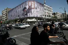 Penduduk menunggang motosikal berhampiran papan iklan yang memaparkan imej bekas Pemimpin Tertinggi Iran, di Teheran, Iran, pada 11 Mei 2026.