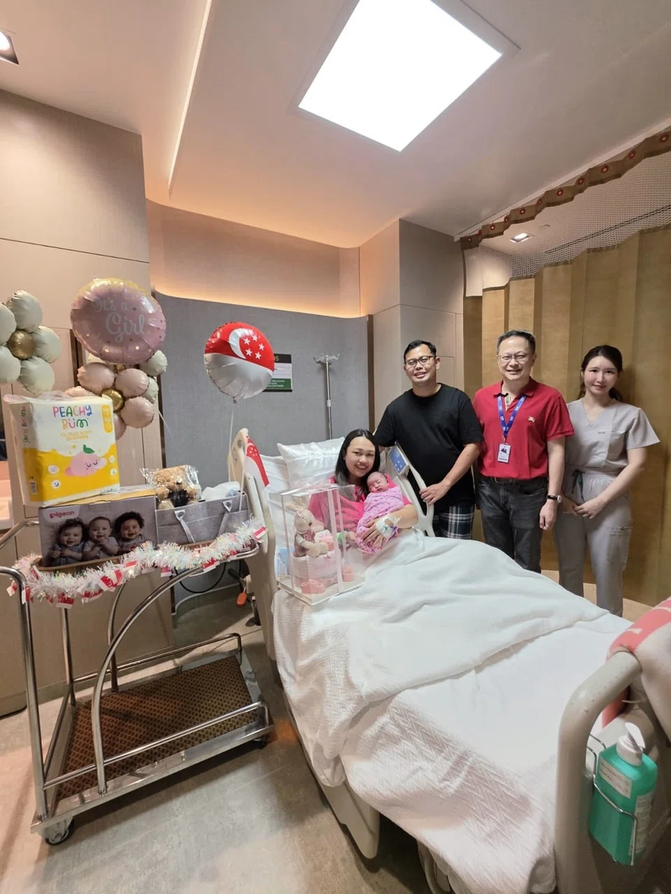 Cik Nabilah Mohd Fadhli (kiri) bersama suaminya Encik Aidil Iskandar Salman (dua dari kiri) menyambut bayi pertamanya, Sofia Insyirah Aidil Iskandar pada 1.13 pagi 9 Ogos. Bersama dalam gambar ialah doktor ginekologi pasangan itu, Dr Celene Hui (kanan), dan Ketua Pegawai Eksekutif Hospital Mount Elizabeth, Encik Yong Yih Ming (dua dari kanan).