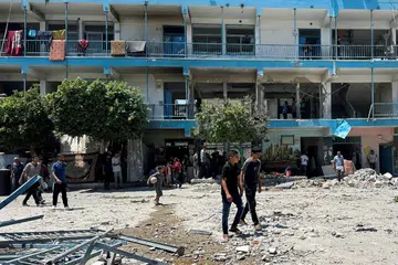 Penduduk Palestin meninjau tapak serangan Israel ke atas sekolah UNRWA yang melindungi orang yang kehilangan tempat tinggal, di kem pelarian Nuseirat di tengah Jaluran Gaza pada 6 Jun.