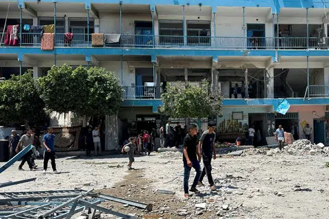 Penduduk Palestin meninjau tapak serangan Israel ke atas sekolah UNRWA yang melindungi orang yang kehilangan tempat tinggal, di kem pelarian Nuseirat di tengah Jaluran Gaza pada 6 Jun.