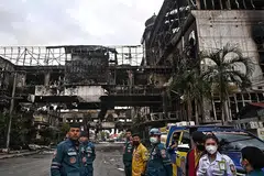 LOMPAT DARI TINGKAP: Pasukan penyelamat mencari mangsa di runtuhan kompleks hotel dan kasino Kemboja yang hangus dan berkata bahawa mereka menjangka menemui lebih ramai mangsa kebakaran itu, yang memaksa orang melompat dari tingkap untuk menyelamatkan diri. - Foto AFP