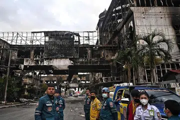 LOMPAT DARI TINGKAP: Pasukan penyelamat mencari mangsa di runtuhan kompleks hotel dan kasino Kemboja yang hangus dan berkata bahawa mereka menjangka menemui lebih ramai mangsa kebakaran itu, yang memaksa orang melompat dari tingkap untuk menyelamatkan diri. - Foto AFP