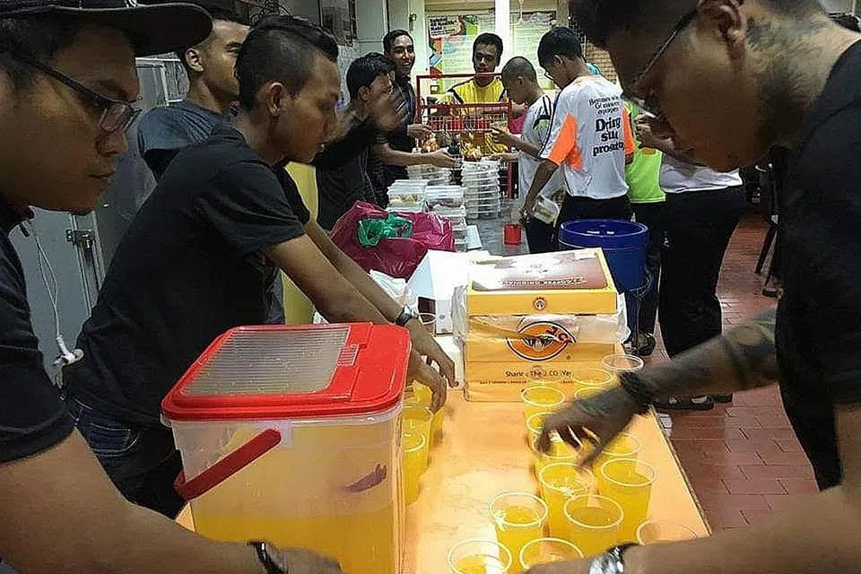BUAT KERJA KEMASYARAKATAN: Anggota dan relawan One Heart Brothers Society (OHBS), sesetengahnya pernah terlibat dalam kumpulan kongsi gelap, tampil menjayakan acara Pesta Amal Muhamadiyah di Bedok North pada Mei tahun lalu. - Foto ihsan OHBS