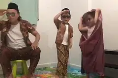 MENCUIT HATI: Keluarga Umar, si cilik berusia lima tahun (tengah), bersama ayah dan adiknya mendendangkan lagu rakyat Chan Mali Chan dengan menggunakan alat-alat kelengkapan rumah sebagai pengganti gitar, mikrofon dan dram. - Foto PROGRAM UJANA OLEH M3@TAMPINES