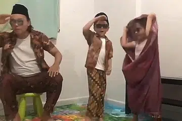 MENCUIT HATI: Keluarga Umar, si cilik berusia lima tahun (tengah), bersama ayah dan adiknya mendendangkan lagu rakyat Chan Mali Chan dengan menggunakan alat-alat kelengkapan rumah sebagai pengganti gitar, mikrofon dan dram. - Foto PROGRAM UJANA OLEH M3@TAMPINES