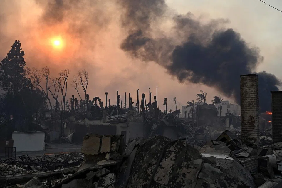 Asap hitam tebal menjulang dari struktur yang terbakar semasa kebakaran Palisades di Pacific Palisades, California, pada 8 Januari 2025. 